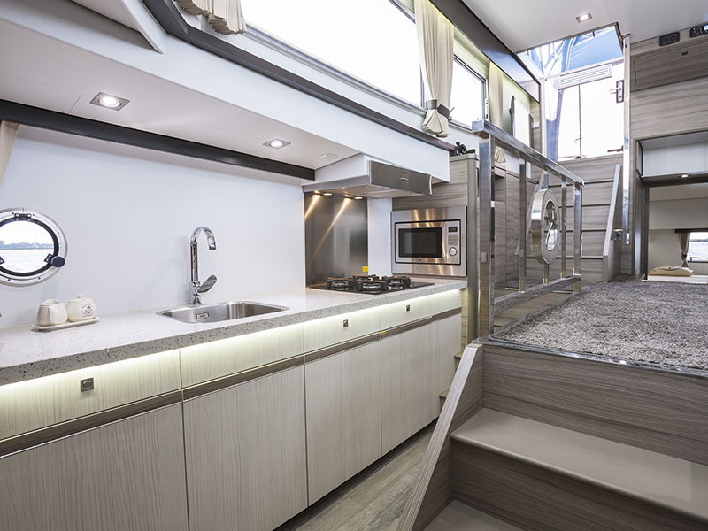 De hoge gangboorden maken een veel praktischere indeling van de leefruimte mogelijk. De kombuis is aan stuurboordzijde helemaal geïntegreerd in de scheepswand.